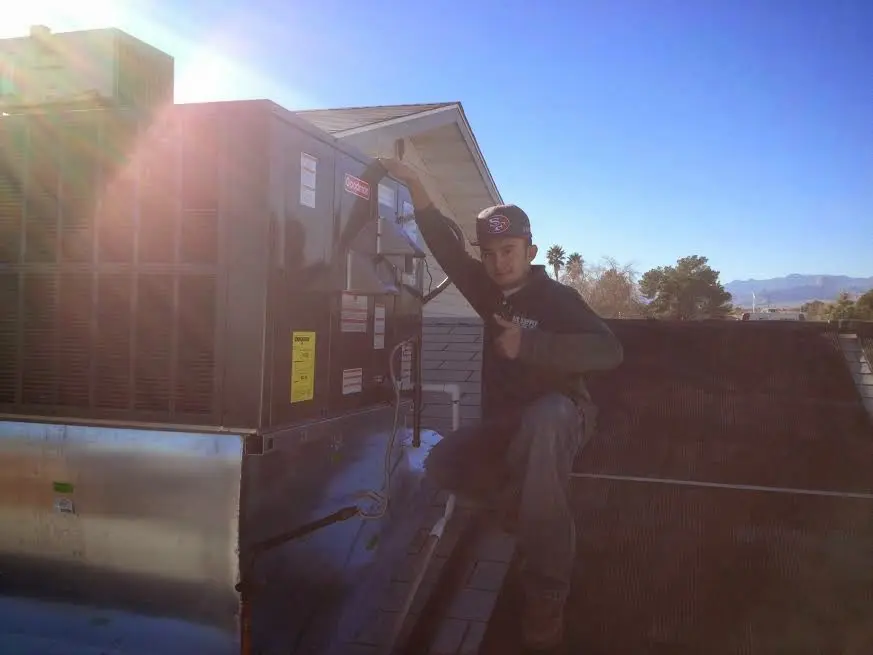 HVAC technician performing Air Duct Repair on a rooftop unit in East Port Orchard